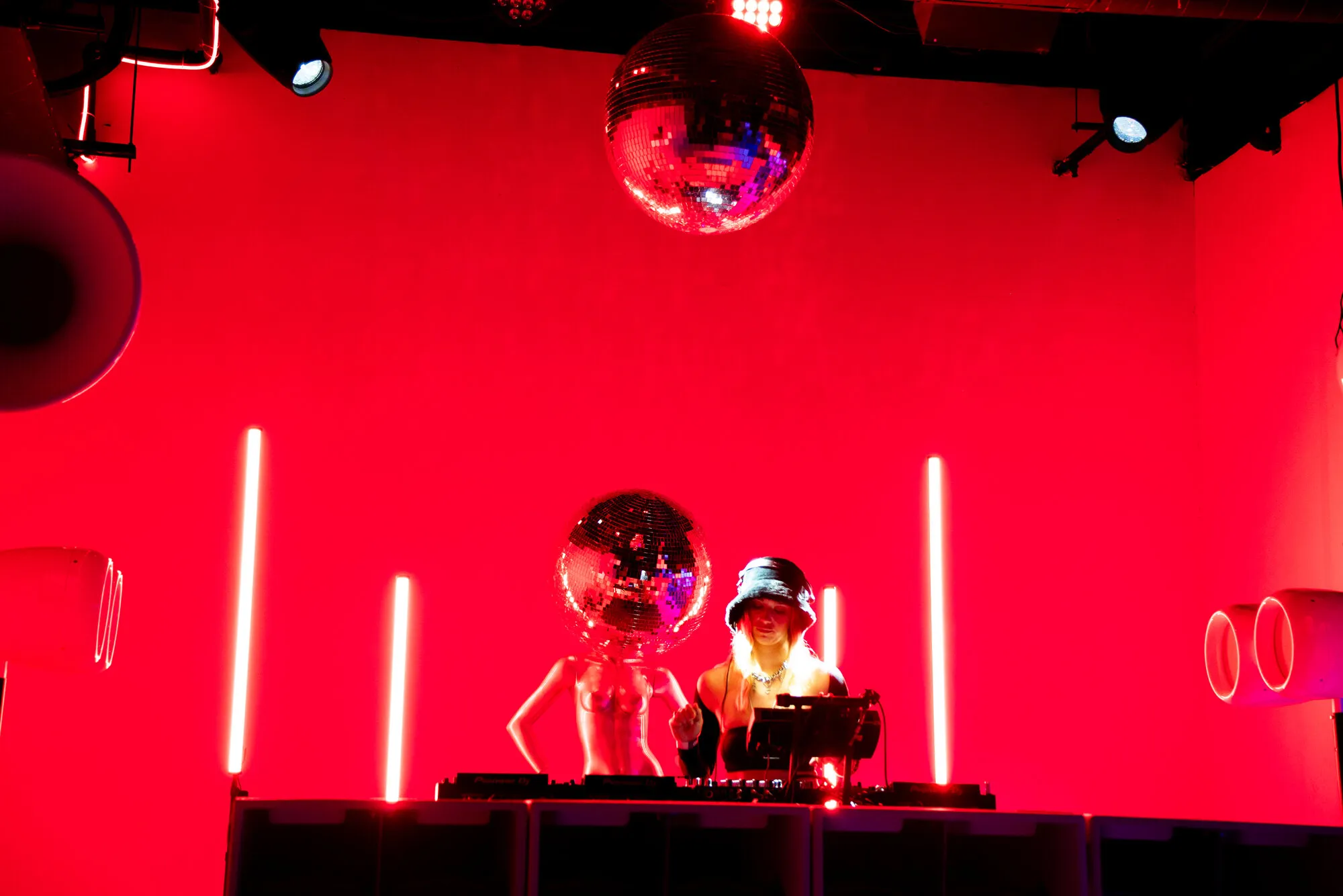 DJ behind a disco ball booth