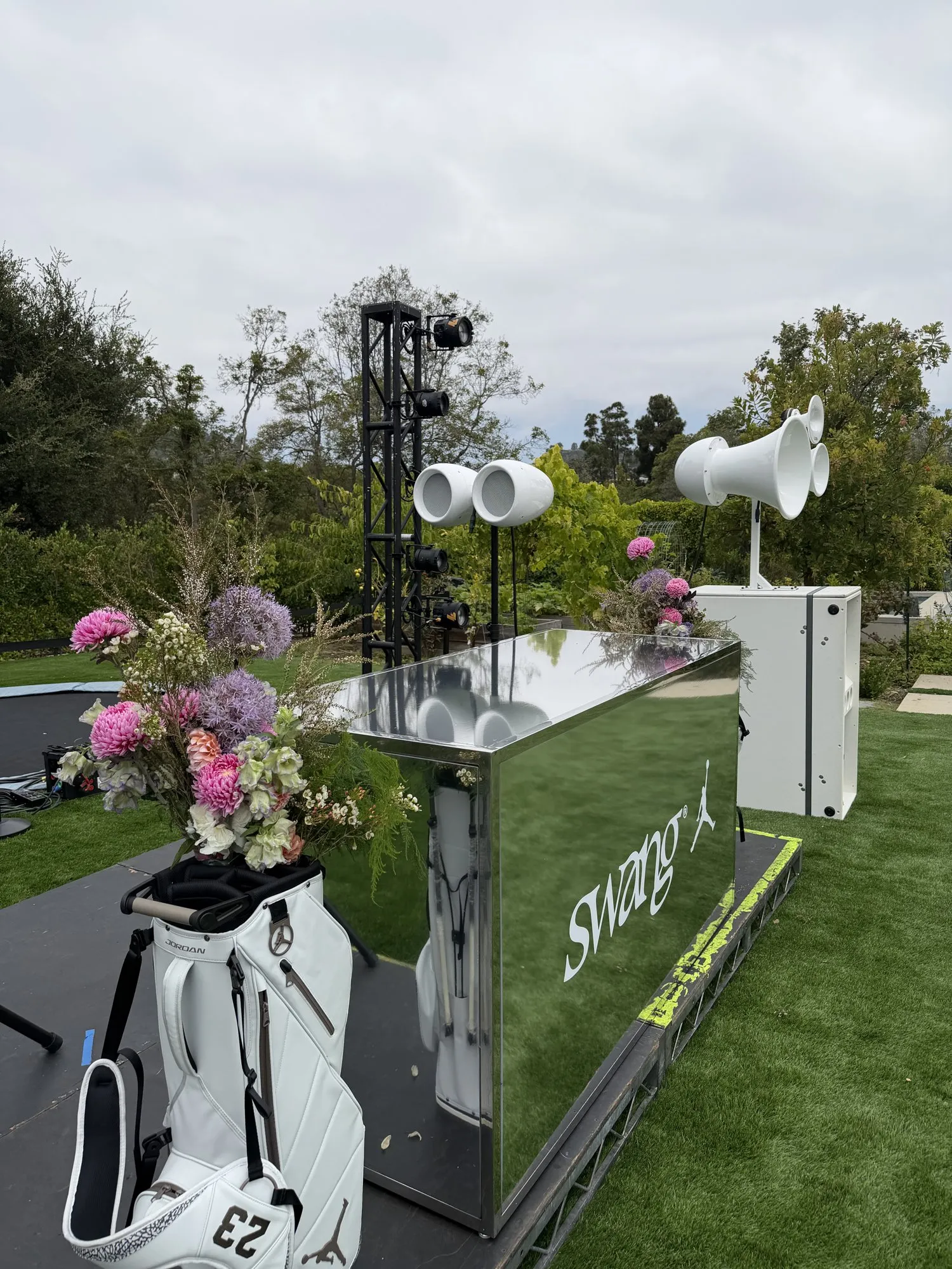White Void Acoustics speakers beside a branded golf set at a Swang event