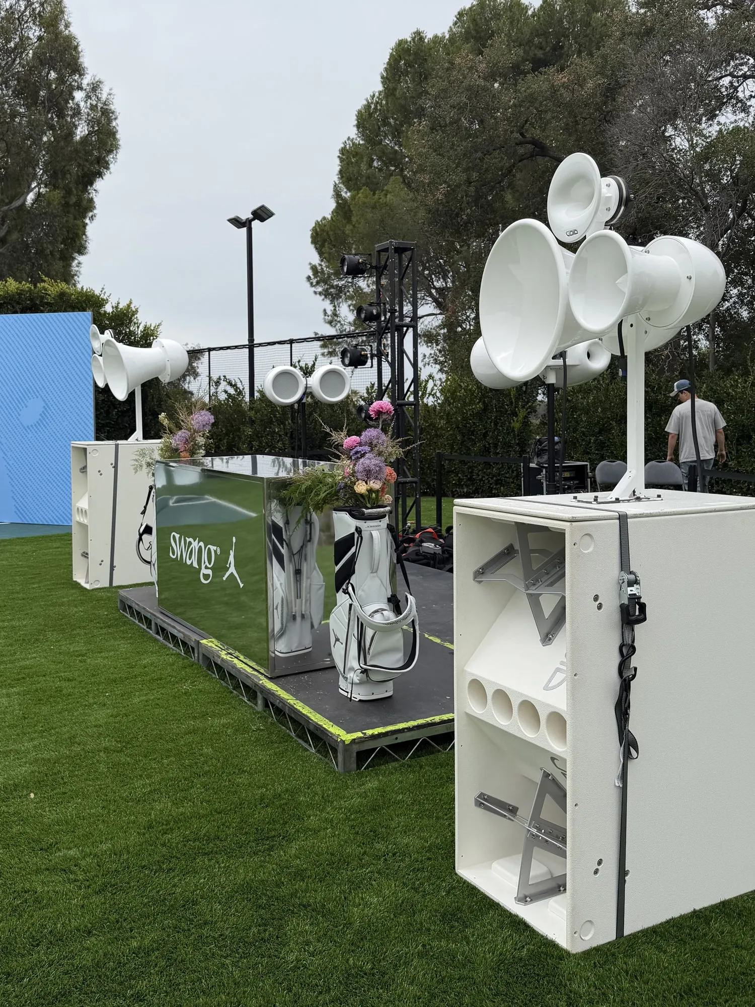 White Void Acoustics stack on a lawn beside a Swang golf set