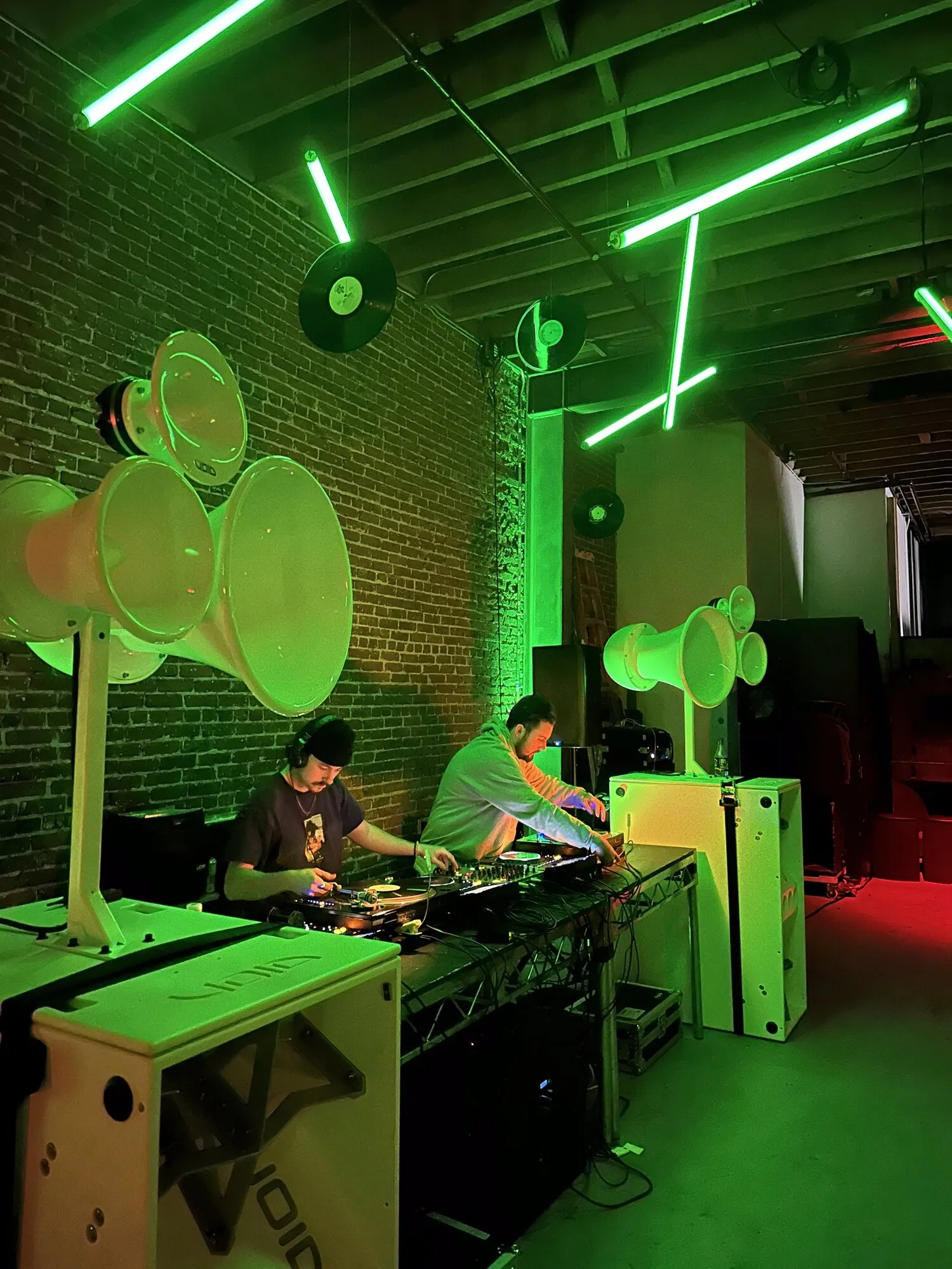 DJs under green neon light